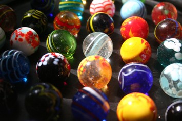 This photo of handmade marbles from West Africa speaks to the multi-dimensional aspects of individual hobbies and/or how different individual hobbies can revolve around a single item.  Marbles:  there's the hobby of making the marbles by hand ... like the old days ... an art form; there's the hobby of playing marbles ... enjoyed by young and old; there's the hobby of collecting marbles for their beauty and craftmanship.  It's often those that played marbles in their youth that become collectors as adults.  Their own marbles (the glass variety!) form the basis of respective collections.  Just a mini discussion on how hobbies get started!  Photo by Sam Fentress.